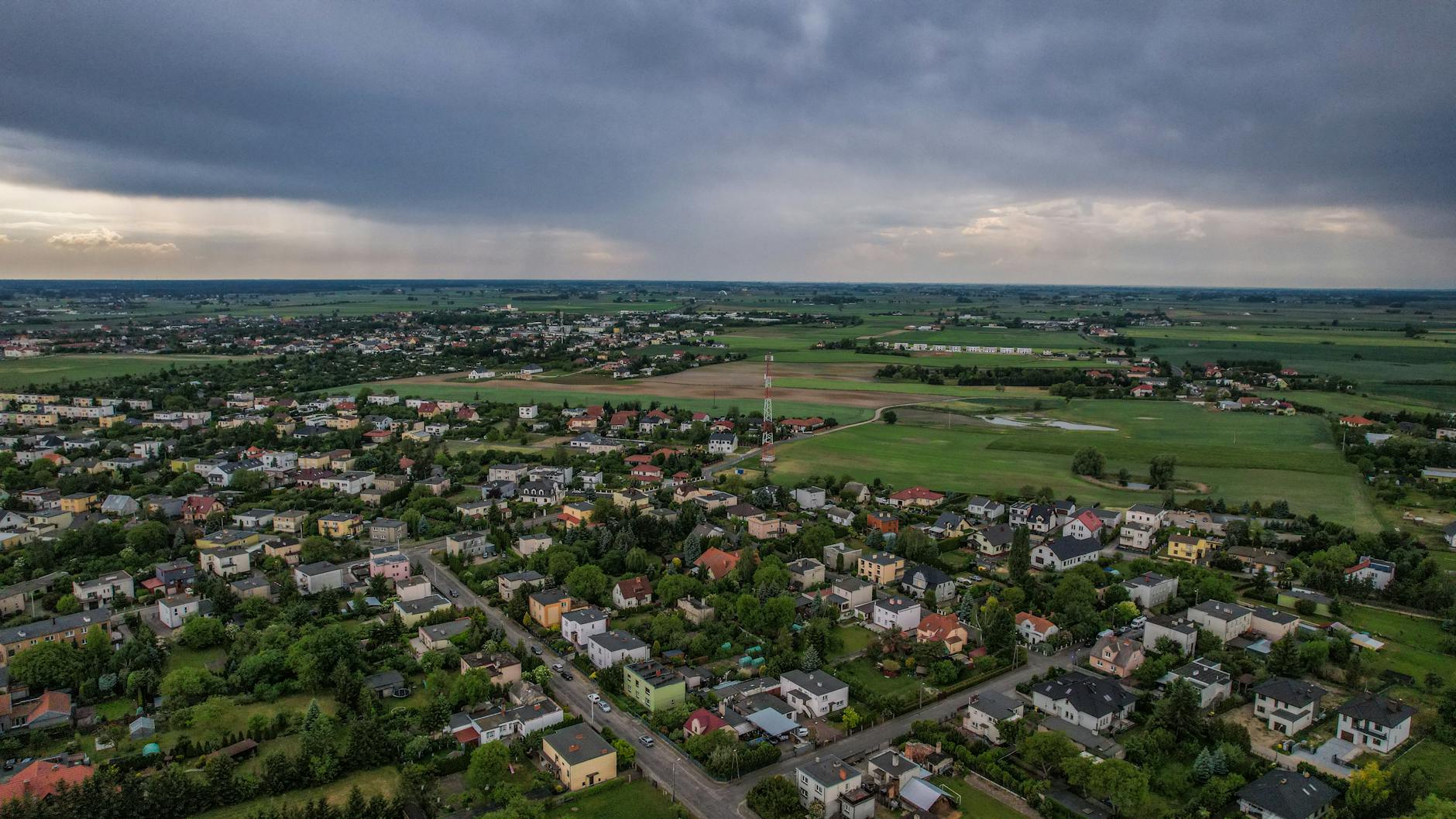 Mieszkańcy Ciechanowa mogą ubiegać się o dofinansowanie zbiorników na deszczówkę. Grafik przedstawia krople deszczu wpadające do beczki.
